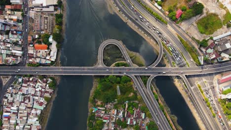 Drone-timelapse-top-down-over-the-river-and-bridge-in-Ho-Chi-Minh-City,-Vietnam