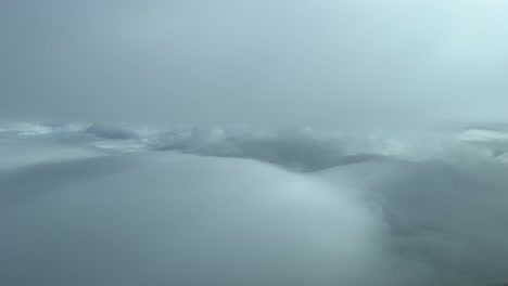 Luftaufnahme-Aus-Einem-Jet-Cockpit,-Während-Sie-Zwischen-Schichten-Weicher-Weißer-Und-Grauer-Wolken-Fliegen