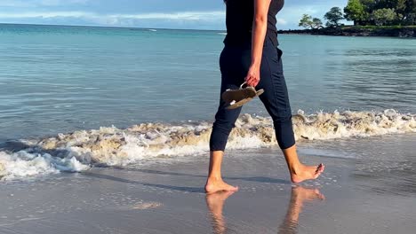 Blick-Auf-Einen-Hawaiianischen-Strand-Und-Sanfte-Wellen,-Wenn-Eine-Frau-Barfuß-Vorbeigeht