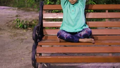 young-kid-meditating-at-wood-bench-in-traditional-dress-at-evening-from-different-angles