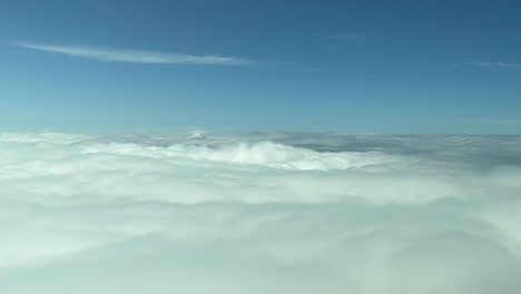 Aerial-cockpit-view-from-a-jet-overflying-top-of-clouds-during-daylight