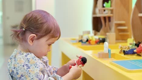 Süßes-Koreanisch-ukrainisches-Kleinkind,-Das-Mit-Spielzeugfiguren-Und-Einem-Puppenhaus-Spielt