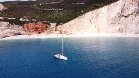 Luxury-Yacht-at-Porto-Katsiki-Beach,-Lefkada-Island,-Greece---Aerial-Circling-Shot