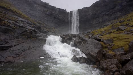 Static-low-angle-shot-of-famous-Fossarfoss-waterfall-on-Streymoy-Island,-with-flowing-water-downhills