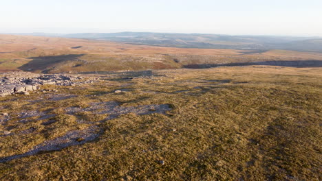 A-4K-Aerial-Drone-Shot-Descending-Over-Moorland-Landscape-with-Wind-Farm-and-Fields-in-Distance