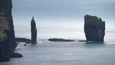 Static-medium-shot-of-Risinn-og-Kerlingin-sea-stacks-on-Eysturoy-Island-during-mystic-cloudy-day,-4k---Faroe-Islands,Denmark
