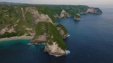 Moody-island-landscape-with-view-of-KelingKing-beach,-steep-sea-cliffs-of-Nusa-Penida,-aerial