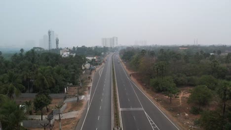 Drone-shot-of-highway-covered-with-trees-on-the-side
