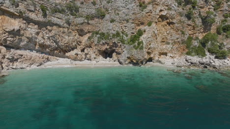 Aerial-5K-Drone-Over-Rocky-European-Cliffside-Beach-With-Turquoise-Sea-In-Dubrovnik,-Croatia