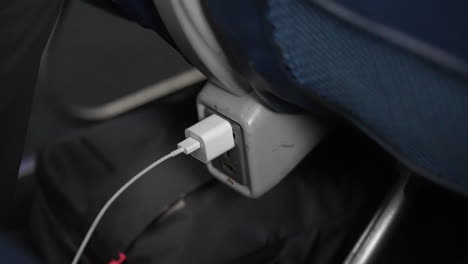 iPhone-charger-plugged-in-on-a-long-flight-on-an-airplane---electricity,-phone,-battery-life,-charger,-transportation