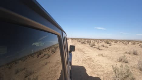 Navigating-rugged-terrain-in-the-backroads-of-the-Mojave-Desert-in-a-four-wheel-drive-vehicle---passenger-side-view