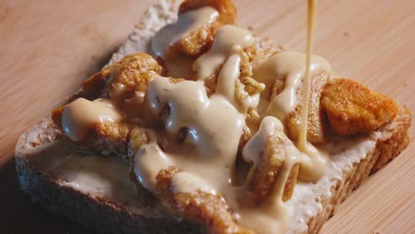 Pouring-French-Dressing-Onto-Whole-Grain-Toast-With-Melted-Cheese-And-Fried-Chicken-Fillet