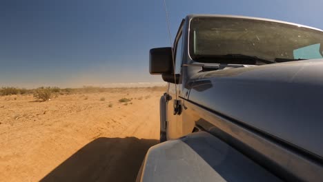 Un-Nuevo-Y-Brillante-Vehículo-Todoterreno-Que-Conduce-A-Través-Del-Polvo-Y-La-Suciedad-Del-Desierto-De-Mojave---Frente-Al-Jeep-Mirando-Hacia-Atrás