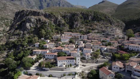 drone-video-passing-the-village-of-Nje-Muaj,-Spile,-Sen-in-Himare,-on-the-Albanian-coast,-laSh8,-until-reaching-the-mountains