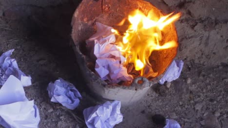 Important-paper-document-burning-inside-trash-bucket,-hands-throwing-away-evidence