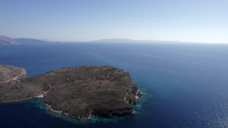 drone-shot-over-an-island-shaped-ledge-on-the-Albanian-coast,-sh8,-Palermo