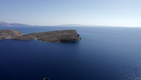 empty-descriptive-plane-with-drone-towards-an-island-shaped-ledge-on-the-Albanian-coast,-sh8,-Palermo