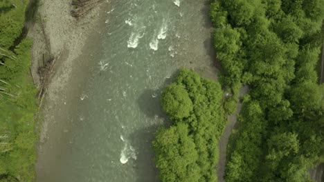 Drone-footage-over-Pacific-Northwest-River-with-forest,-road,-top-down-bird's-eye-view