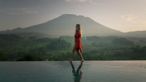 Attractive-blond-digital-nomad-woman-on-morning-business-phone-call-in-bikini,-Volcano-Agung