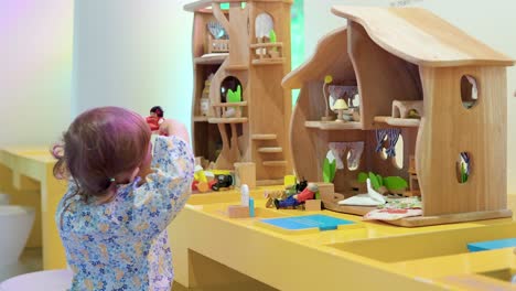 2-jähriges-Kleinkind,-Das-Kreativ-Mit-Puppenfiguren-In-Einem-Puppenhaus-Spielt