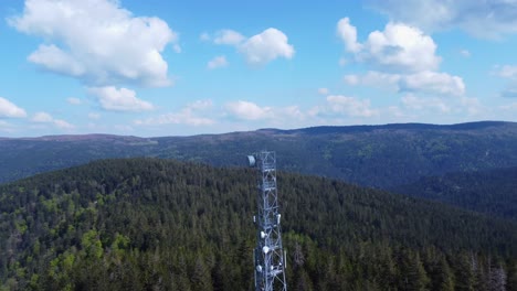 Aerial-orbit-view-around-a-5G-telecom-antenna-mast-pylon-among-mountain-forest-in-Sérichamp-Vosges-France-4K