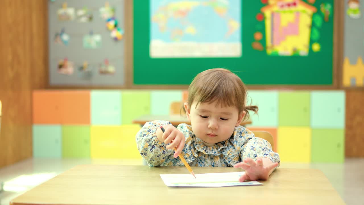 premium-stock-video-a-2-year-old-multiracial-girl-drawing-with-paper