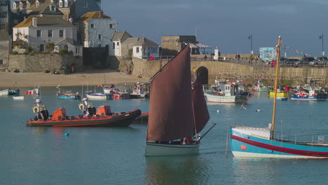 Sailing-Traditional-Cornish-Boat-With-Red-Sail-In-The-Harbour-Of-St