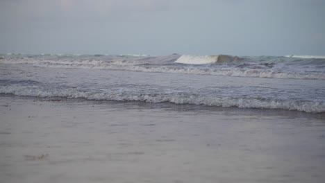 Super-Slow-Motion-Shot-Of-Small-Waves-Rolling-And-Breaking-On-Beach-Shore-During-Grey-Evening-Twilight-After-Sunset