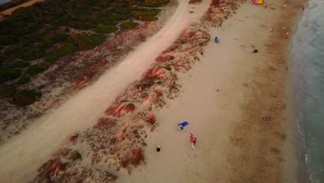 A-drone-flies-along-a-sandy-beach-in-Puglia,-southern-Italy
