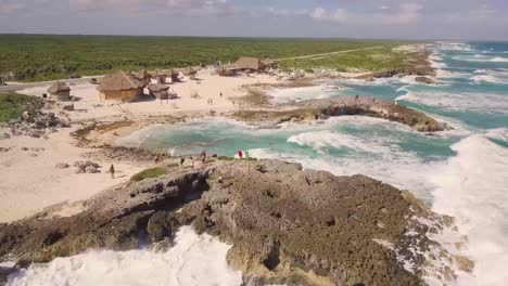 Aerial-Drone-View-of-Shoreline-in-Tulum-with-beach-road-between-jungle-and-Caribbean-Sea