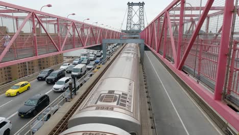 Die-U-bahn-Fährt-über-Die-Williamsburg-Bridge-In-New-York-City,-Während-Fußgänger-Darüber-Radeln-Und-Autos-Im-Verkehr-Warten