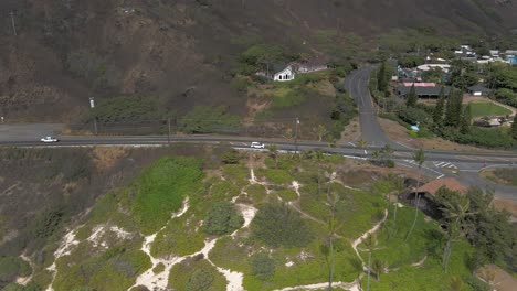 Aerial-view-of-car-driving-along-scenic-Hawaiian-highway-on-sunny-day