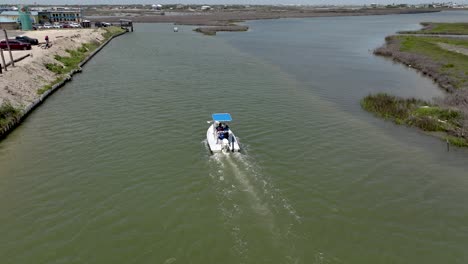 Aerial-view-of-a-Center-console-boat-idling-in-to-port-at-the-Cove-harbor-Marina-in-Rockport,-Texas-in-4K