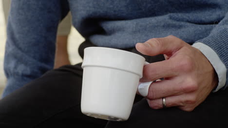 Middle-aged-man-holding-coffee-cup-drinking-close-up-hold-hand-hands-office-space-working-worker-job-break-lunch-colleagues-discussing-conversation-conversing-wrist-hot-drink-talking-men-listening