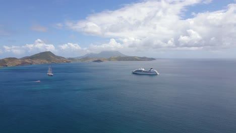 Aerial-view-of-a-frigate-and-a-cruise-liner-on-the-coast-of-Saint-Kitts-and-Nevis---pull-back,-drone-shot
