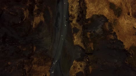 Luftbild-Von-Oben-Auf-Einen-Fluss,-Der-Zwischen-Isländischem-Hochland-Und-Vulkanischem-Schwarzem-Sand-Fließt