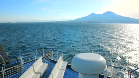 Mount-Vesuvius-From-The-Empty-Deck-Of-Ferry-Boat-Cruising-The-Sea-With-Glistening-Water-In-Italy-On-Sunny-Day