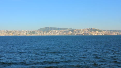 Parte-Continental-De-La-Ciudad-De-Nápoles-Desde-Un-Ferry-Navegando-En-El-Mar-Azul-En-Italia