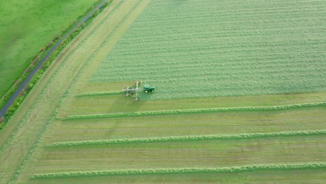 Tracking-Aerial-Side-Shot-Of-A-Farmer-Cutting-Silage-On-A-Warm-Summers-Day,-Scotland