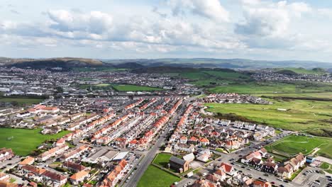 Large-houses-in-the-residential-areas-of-a-Welsh-town-on-the-coast-among-green-lawns-in-the-hilly-countryside-on-a-partly-cloudy-day