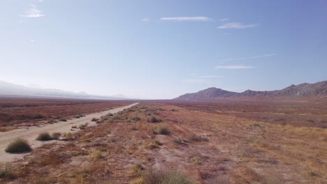 Imágenes-De-Drones-Al-Revés-De-Una-Carretera-Polvorienta-En-El-Desierto-De-California