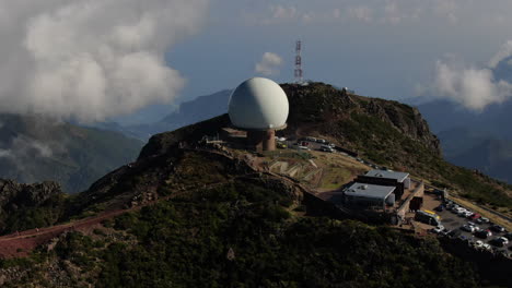 Kreisförmiger-Drohnenflug-Um-Die-Radarmeteostation-Auf-Einem-Der-Berge-Von-Madeira-Mit-Den-Wolken-In-Der-Ferne-Gegen-Die-Anderen-Berggipfel