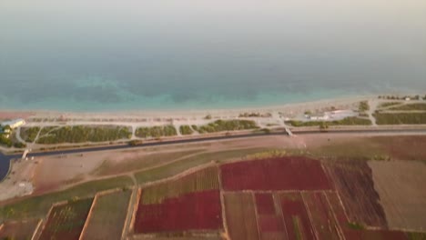 A-drone-shows-the-horizon-of-the-mediterranean-sea-during-a-sunset-passing-over-a-sandy-beach-in-puglia,-southern-italy
