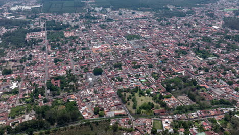 Hiperlapso-Aéreo-Sobrevolando-Y-Montaña-Para-Ver-El-Centro-Histórico-De-Antigua,-Guatemala