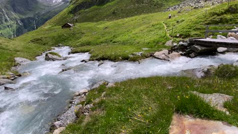 Kardanische-Wanderung-über-Einen-Holzsteg-über-Einen-Wilden-Fluss-Im-Wunderschönen-Lüsenstal-In-Österreich-Mit-Hohen-Bergen-Im-Hintergrund