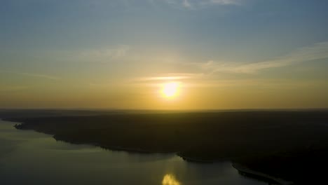 Wide-and-beautiful-view-of-sun-over-dam-on-a-huge-sunrise-in-Alentejo,-Portugal