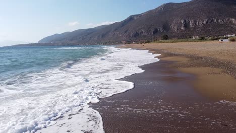 Splashing-Waves-at-Sandy-Beachline-in-Monemvasia,-Peloponnese,-Greece---Aerial