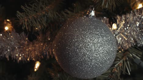 Silberglitzernder-Weihnachtsbaumschmuck-Mit-Weißen-Punkten,-Die-Am-Baum-Hängen,-Pfannentrieb