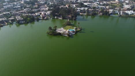 Drone-video-of-a-lagoon-or-lake-with-a-small-island-in-the-middle-connected-by-a-bridge-to-land
