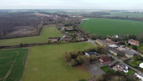 Idyllic-aerial-rising-view-above-Nonington-small-town-farming-countryside-settlement-and-fields